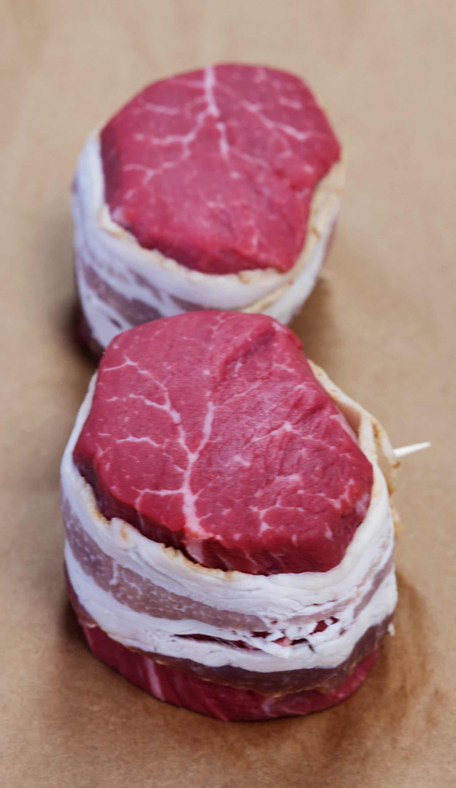 Fresh Wagyu beef steaks wrapped in bacon, ready for grilling or cooking.